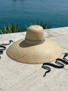 The extra-wide brim sun hat is woven, like a basket, with dried palm tree leaves. Then it is shaped with the same antique hat mold we use to shape our Daisy sun hat.  This super wide-brimmed hat will glamorously shield you from the sun. The Geranium is woven with wider pieces of palm leaf vs. The Daisy is woven with fi Summer Brimmed Sun Hat Made Of Palm Leaf, Artisan Boater Hat With Curved Brim For Beach, Flat Brim Toquilla Straw Panama Hat For Sunbathing, Handwoven Toquilla Straw Sun Hat With Curved Brim, Flat Brim Panama Hat In Toquilla Straw For Sunbathing, Artisan Panama Hat With Curved Brim For Beach, Artisan Natural Hat Band For Beach, Artisan Natural Sun Hat With Curved Brim, Artisan Natural Sun Hat For Beach