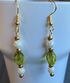 These dangling Light green acrylic beads with pearl and gold tone beads create a fresh look for spring or St. Patrick's Day. Wear them with jeans or dress up and wear them on a special occasion. These earrings or two or three pairs of earrings would make a perfect gift to friends and family and even yourself. Give as a gift for a variety of holidays such as Christmas and Easter or a life event including birthdays, anniversaries, and graduations.  If you have something different in mind please contact me and I can make you a custom order just for you! Jewelry Care As will all jewelry remove before showering, sleeping and activates that cause sweating.Everything is made to order and assembled by hand with love, care, and attention to detail.  This item or two or three items would make a perf Spring Gold Jewelry With Pearl Drop, Spring Pearl Drop Gold Jewelry, Spring Pearl Drop Gold Earrings, Gold Pearl Drop Earrings For Spring, Spring Gold Pearl Drop Earrings, Green Dangle Earrings For Spring, Green Gold Beaded Drop Earrings, Green Drop Earrings With Gold Beads, Green Dangle Jewelry For Spring