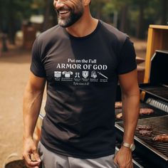 a man standing in front of an open grill with meat on it and the words, put on the full armor of god