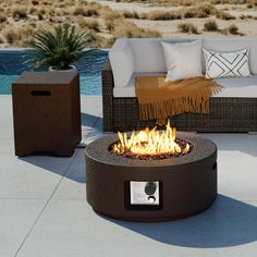 a fire pit sitting on top of a cement floor next to a couch and table