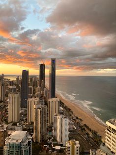 an aerial view of a city with tall buildings and the ocean in the foreground