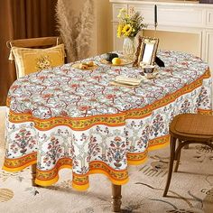 a dining room table covered with a white and yellow table cloth