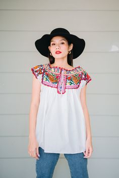 "This vintage Mexican hand embroidered cross stitch blouse is made from lightweight cotton with beautiful crochet birds and floral cross stitch in colour mix. Condition: In Very Good Vintage Condition **small brown spot under the bust (front) 3 small spots (back) shown in the last picture Details and Measurements (Inch) size estimate: L *Measurements are taken in inches with the garment laying flat. BUST: 40 \" FULL LENGTH: 27.5 \" SLEEVES LENGTH: 3.5\" Material = cotton, cross stitch,crochet Ou Bohemian Peasant Top With Multicolor Embroidered Neckline, Folk Peasant Top With Multicolor Embroidered Neckline, Folk Style Multicolor Embroidered Peasant Top For Festivals, Folk Style Peasant Top With Multicolor Embroidery For Festival, Cotton Peasant Blouse With Embroidered Neckline, Bohemian Blouse With Intricate Multicolor Embroidery, Folk Style Peasant Top With Multicolor Embroidery, Folk Style Cotton Peasant Top With Floral Embroidery, Folk Style Peasant Top With Multicolor Geometric Embroidery