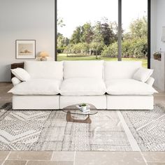 a large white couch sitting in a living room next to a window