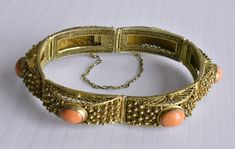 This is a very fine vintage Chinese gold gilt silver filigree hinged bracelet with 6 high quality and high density genuine and natural bezel-set oval salmon red coral cabs. Marked "SILVER". In great vintage condition. It measures 7-1/4" long by 1/2" wide and weighs 29.8 grams. Each of the 6 coral cabs measures 10 mm x 8 mm each.  From the 1940's. Formal Coral Jewelry With Cabochon Details, Formal Coral Jewelry With Cabochon, Vintage Oval Coral Jewelry, Vintage Coral Oval Jewelry, Elegant Oval Coral Jewelry, Elegant Coral Oval Jewelry, Formal Coral Oval Jewelry, Vintage Coral Jewelry For Wedding, Coral Oval Jewelry For Weddings