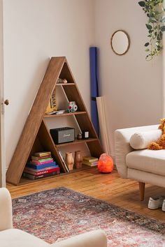 a living room filled with furniture and a book shelf next to a white couch in front of a window