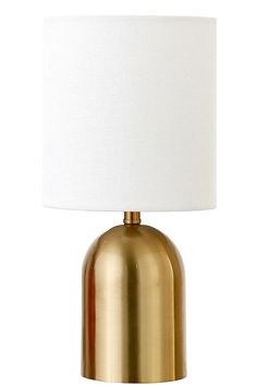 a gold table lamp with a white shade on the top and bottom part of it