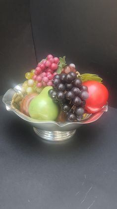 a metal bowl filled with lots of fruit