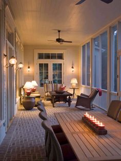 a room with many chairs and lights on the ceiling, along with a table that has candles in front of it