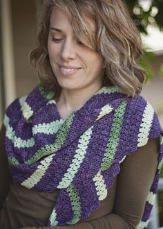 a woman wearing a purple and green crocheted scarf