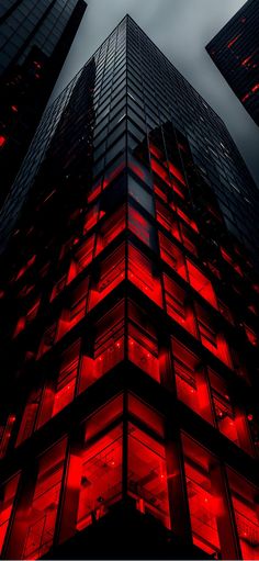 the building is lit up with red lights on it's sides and windows,