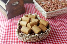 two baskets filled with food sitting on top of a red and white checkered table cloth