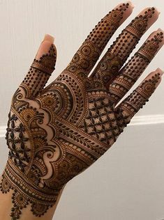 the hand is decorated with henna designs on it's fingers and hands, as well as an intricate pattern