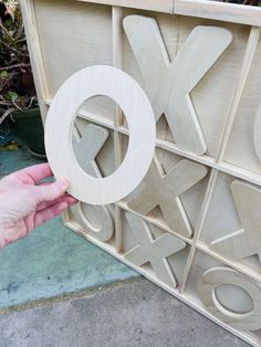 a person is holding a wooden object with the letter x in it's center