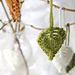 three plants are hanging from wire in the snow and one plant is green with white flowers