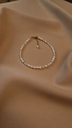 Elevate your accessory collection with our exquisite gold plated anklet featuring natural pearls and sparkling fianite accents. This anklet exudes elegance and charm, making it a versatile piece that complements any outfit, from casual to formal attire. Crafted with attention to detail, the combination of pearls and fianite creates a sophisticated and timeless look that will surely turn heads. Ideal for gifting, this ankle bracelet with pearls and fianite makes a perfect present for various occasions and recipients. Whether you're celebrating a birthday, anniversary, or special milestone, this anklet is a thoughtful and stylish gift choice. It's also ideal teenage girl gifts. Perfect bridesmaids, adding a touch of elegance to wedding day attire or as a token of appreciation for their suppo Gold Pearl Anklet, Anklets Aesthetic, Pearl Ankle Bracelet, Bracelet With Pearls, Pearl Anklet, Beach Anklets, Aesthetic Jewelry, Jewelry Summer, String Of Pearls