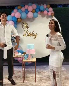 a man standing next to a woman in front of a cake