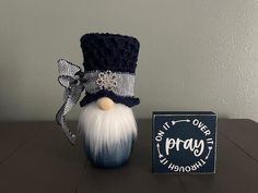 a small blue and white gnome with a hat on it's head next to a box