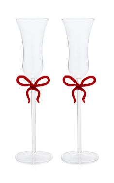 two empty wine glasses with red bows on each one and the other in different sizes