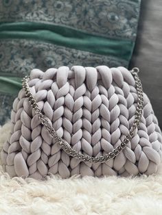 a white purse sitting on top of a fluffy rug