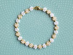 Simple beaded flower bracelet with white and light caramel colors, with gold beads between each flower. You can choose between having an extender chain or not. If you, for example, choose 16cm with extender, the bracelet will be 16cm + 3cm extender chain. The chain and clasp are 24k gold plated brass. Each jewelry item comes in a colorful envelope, as seen in the last picture, and is ready to be gifted. You can find more bracelets here https://www.etsy.com/shop/GirassolBeads?section_id=33629858 Handmade Dainty Pearl White Bracelets, White Dainty Flower Shaped Beaded Bracelets, Delicate White Flower Beaded Bracelets, Delicate White Flower Shaped Beaded Bracelets, White Dainty Beaded Bracelet With Flower Charm, White Dainty Bracelet Jewelry, Dainty White Beaded Bracelet With Flower Charm, White Flower-shaped Bracelet With Tiny Beads, Dainty White Bracelet Jewelry