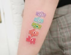 a person with a small tattoo on their arm that has five little bears painted on it