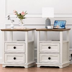 two white nightstands with drawers and a laptop on top