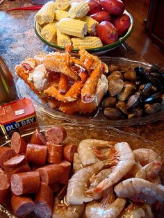 there are many different types of food on the counter top, including shrimp, mussels and potatoes