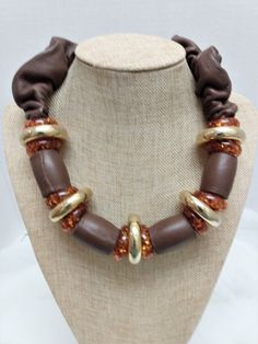 Here is another unique boho necklace from Italian designer, Wilma Spagli.  The necklace features chocolate brown leather tube beads and donut rings in burnt orange confetti and gold.  The necklace also has scrunched brown leather leading to the stamped lobster claw clasp.  The necklace measures 20 inches. Luxury Brown Hand-strung Necklaces, Adjustable Brown Jewelry With Large Beads, Adjustable Brown Necklaces, Vintage Brown Jewelry, Brown Jewelry With Wooden Beads, Donut Rings, Gold Donuts, Orange Confetti, Donut Ring