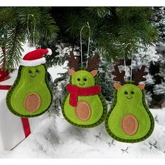 three green ornaments hanging from a christmas tree