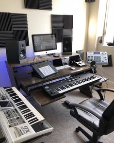 an electronic keyboard sitting on top of a wooden desk next to a chair and computer monitor