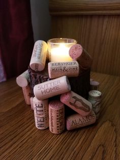 a candle that is sitting on top of some wine corks with words written on them