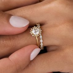 a woman's hand holding a diamond ring