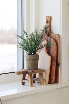 a potted plant sitting on top of a window sill next to a cutting board