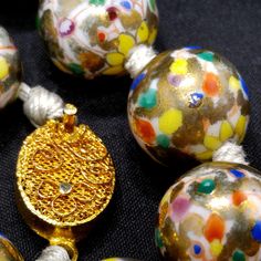 *Description: This necklace is a Chinese hand painted, hand knotted floral beaded necklace with a filigree gold tone sliding clasp from around the 1940s. The beads are a white background with flowers in primary colors with splashes of gold. Each round bead is 14mm and the hand knotted string is white in color. It is a heavier necklace; weighing in at 4 ounces. The gold paint is very striking on each bead and gives the necklace a great vintage look. This would be a great addition to your vintage Vintage Adjustable Beaded Necklaces For Festivals, Vintage Polished Beads For Festive Occasions, Vintage Hand-strung Beaded Necklace With Round Beads, Vintage Large Beads For Festive Occasions, Vintage Beaded Necklaces With Large Beads For Festive Occasions, Festive Vintage Beaded Necklaces With Polished Beads, Vintage Gold Beaded Necklaces For Gifts, Festive Vintage Large Beads, Vintage Large Beads For Festivals