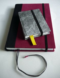 a red and black book with a yellow strip on it next to a pair of scissors