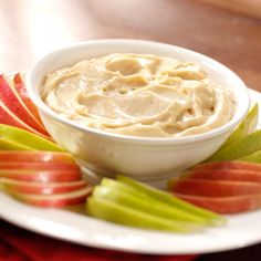 a white plate topped with an apple and dip