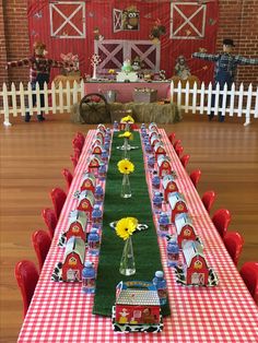 a long table set up with red chairs and white checkered runner on the floor