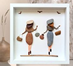 two people made out of rocks in a shadow box