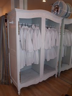 there are many white dresses on display in this room and one is hanging from the ceiling