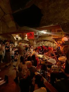 a group of people that are standing in front of some drum sets and microphones