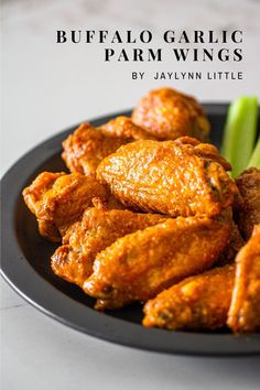 buffalo garlic parmesan wings on a black plate with celery sticks in the background