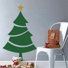 a wall decal with a christmas tree and presents on the floor next to it