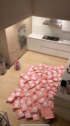 a pile of pink bags sitting on top of a kitchen floor next to an oven