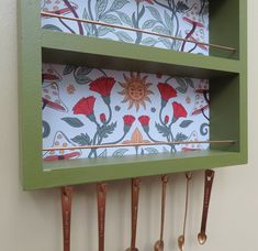 a green shelf with utensils hanging from it