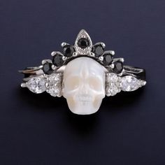 Introducing the Pearl Skull Ring 'Be My Queen' with Crown--a striking fusion of elegance and rebellion that commands attention. This Silver Gothic Jewelry piece is designed for those who dare to stand out and make a bold statement with their accessories. Crafted from high-quality silver, this ring set features a meticulously detailed skull adorned with a regal crown, accented by lustrous pearls. The design embodies a gothic allure while offering a touch of sophistication with its stackable funct Witchy Rings, Goth Wedding Ring, Pearl Skull, Rings Goth, Goth Ring, Gothic Engagement Ring, Crown Silver, Skull Wedding, Gothic Earrings