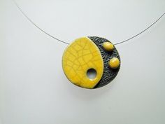 Unique raku ceramic necklace. This necklace is made of a bead entirely shaped by hand. Lava stone texture effect contrasting with the smooth and shiny yellow and crackled enamel. A unique piece inspired by the world of Japanese cartoons and modern art. Textured bead with beautiful crackling effects specific to raku firing. Length of the steel cable adjustable from 39 to 44 cm. Closing by steel snap hook and extension chain of 5cm. If needed I can adapt the length to your needs on request.   Necklace delivered in its pocket ready to offer. For a gift I can slip a word of your share in the package. The stages of manufacture -My beads are handmade. -A first firing in an electric kiln, then enameling session while concentrating to give a neat rendering. -A second firing in a Raku kiln: in this Hand Painted Yellow Polymer Clay Jewelry, Hand-painted Yellow Polymer Clay Jewelry, Unique Hand Painted Yellow Jewelry, Unique Yellow Polymer Clay Jewelry, Artistic Handmade Yellow Necklace, Modern Handmade Yellow Jewelry, Unique Yellow Round Pendant Jewelry, Raku Firing, Raku Kiln