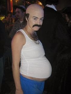 a woman with a fake moustache on her stomach wearing blue pants and a white tank top