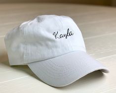 Personalized and Adjustable Dad Hats! Embroider custom names on your hats with our most popular font! These hats make great personalized gifts for women, Bridesmaid Gifts, Birthday Gifts, Christmas Gifts, and more! Free Shipping on orders over $35 Hat Details: -Adjustable Brass Clasp -Embroidered -Permanent Stitching -Hat Color Options: Black, White, Pink *Each color hat will have the corresponding thread color and font seen in the listing pictures* Personalized Adjustable Brimmed Hats, Personalized Dad Hat One Size, Adjustable Hats With Letter Print For Graduation, Customizable Adjustable Dad Hat With Curved Brim, Personalized Adjustable Baseball Cap With Curved Brim, Personalized Adjustable Dad Hat, White Personalized Snapback Hat With Curved Brim, Customizable White Dad Hat One Size Fits Most, White Customizable Adjustable Dad Hat