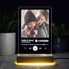 an image of a music player on a table with a cup and plant in the background